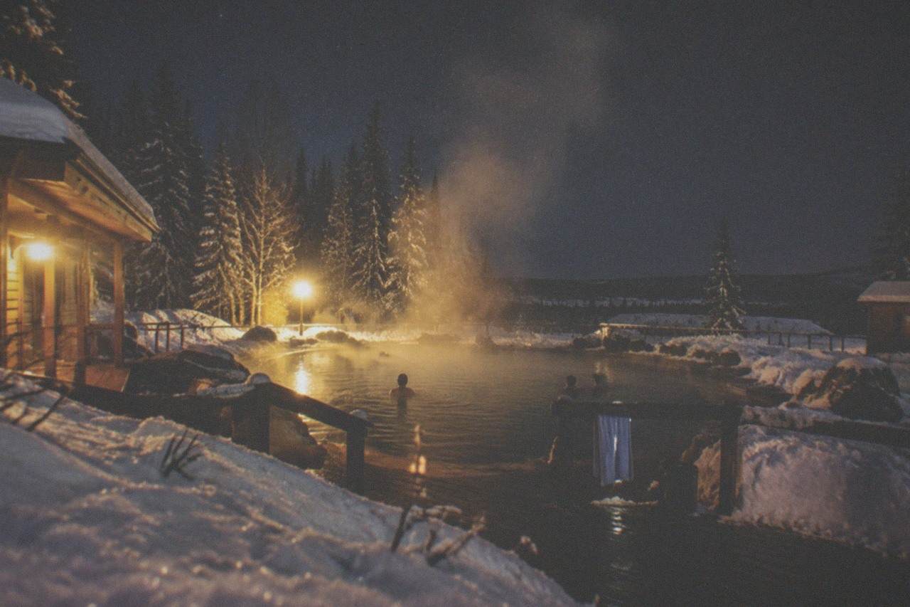 Steam rising from an outdoor hot springs pool under a starry winter sky in interior Alaska.