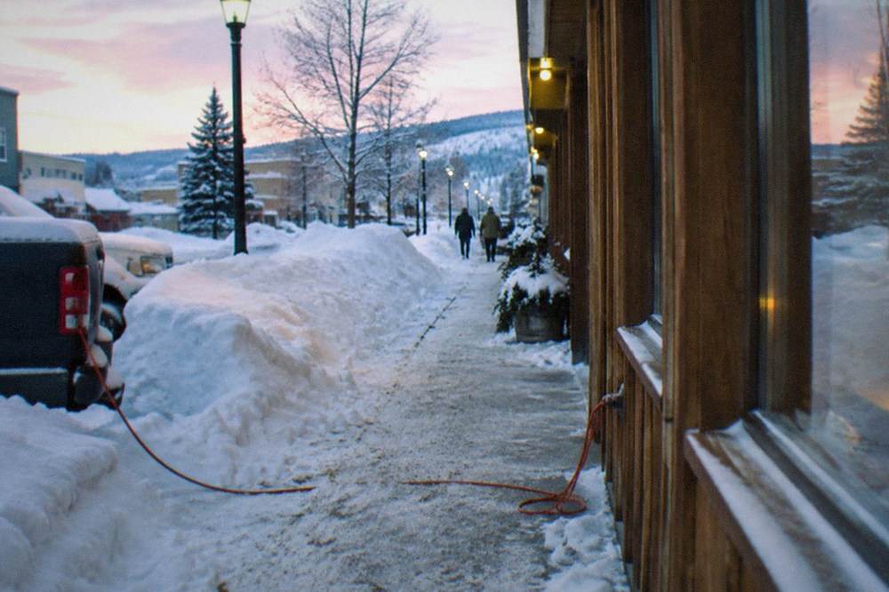 Downtown Fairbanks street in deep winter with snow banks along the sidewalks in early afternoon twilight