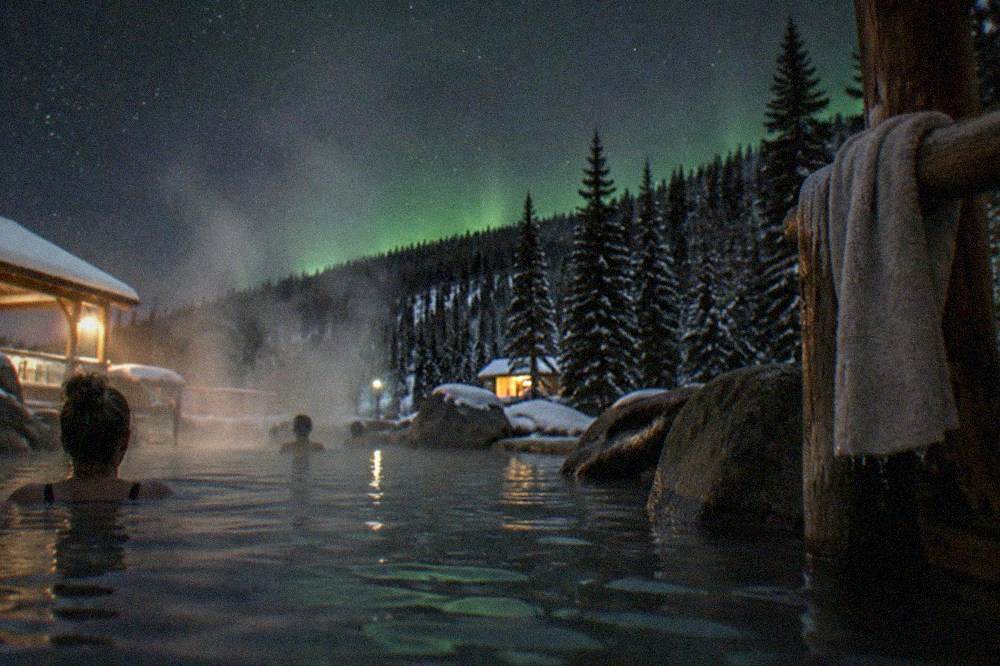 Steam rising from an outdoor hot springs pool under a starry night sky in the Chena hills