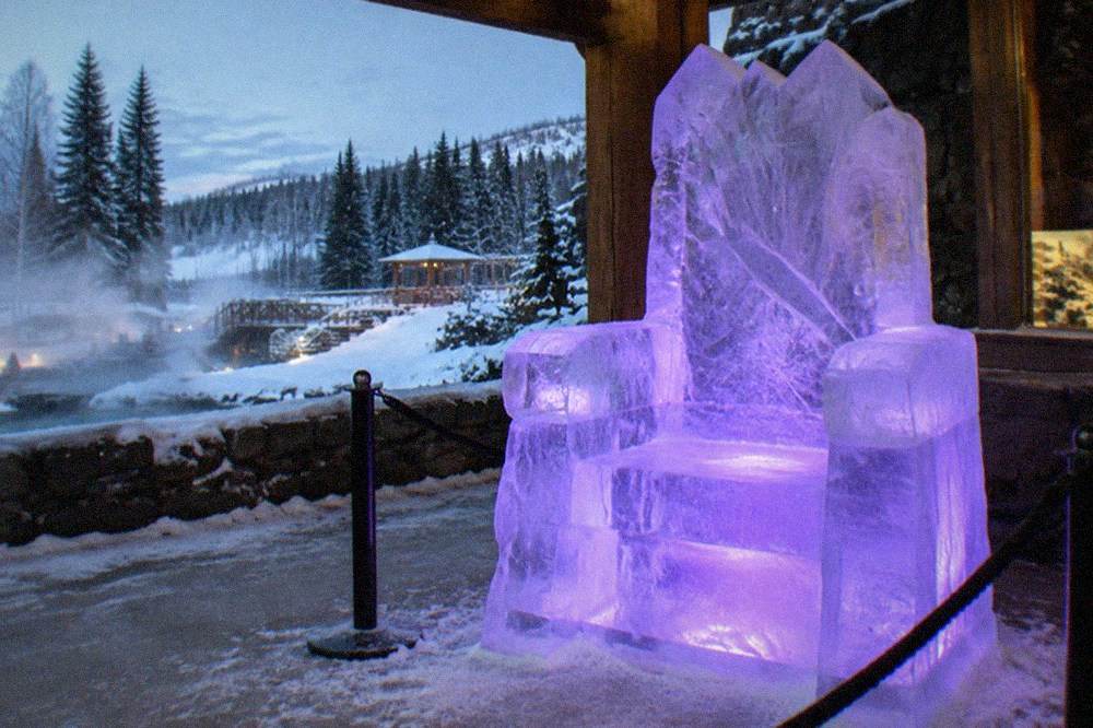 A carved ice throne glowing under purple light in a frozen gallery