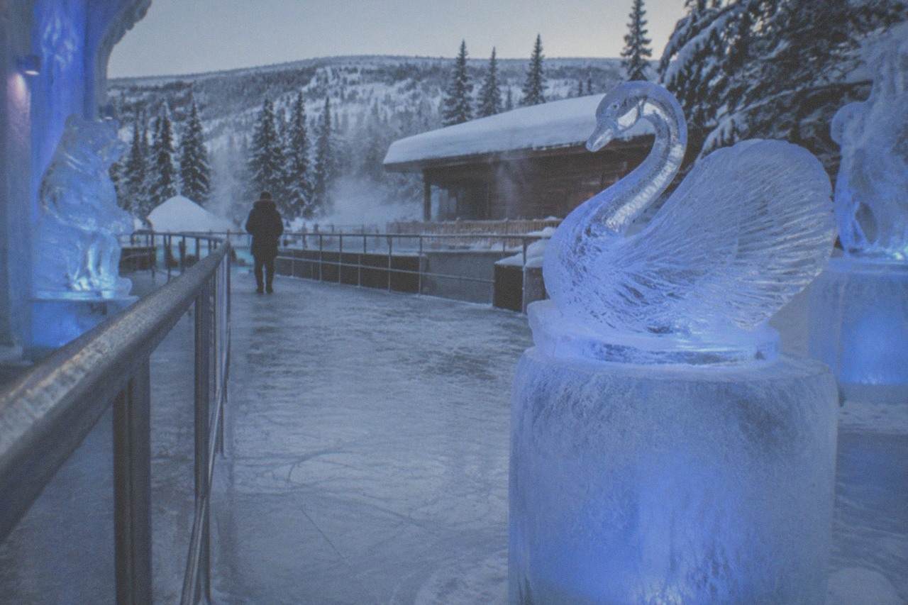 Illuminated blue ice sculptures inside a frozen museum gallery