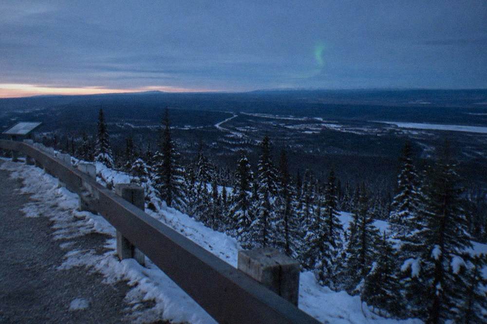Snowy hilltop overlook facing a wide dark northern horizon at dusk