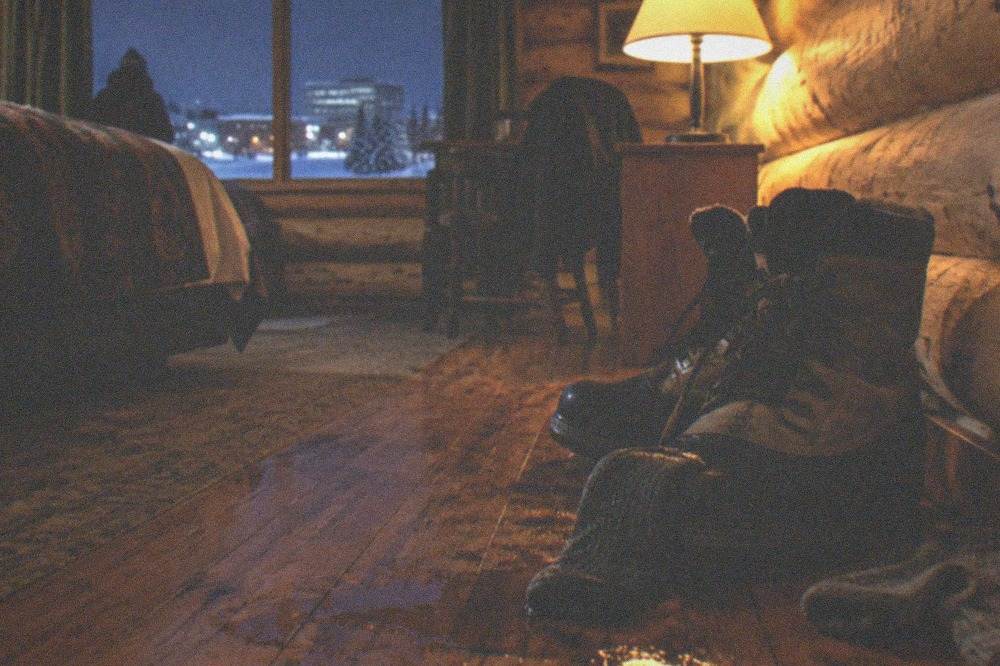 Insulated winter boots and thick wool socks on a wooden floor